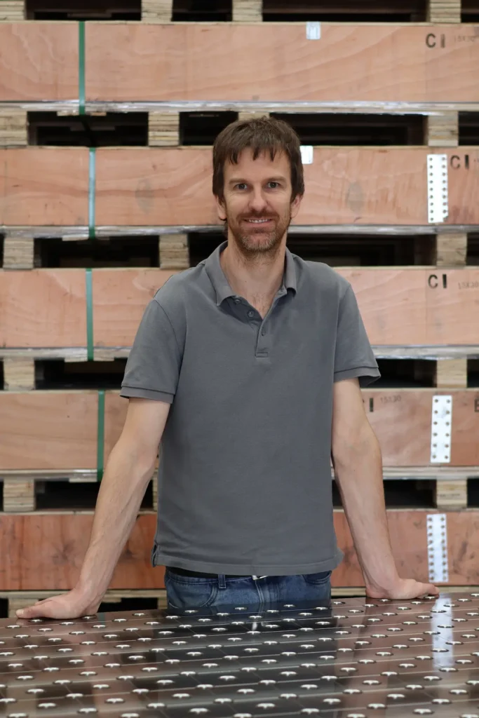 Ray, founder of Tenaxis, standing with a CNC-machined modular welding fixture table.