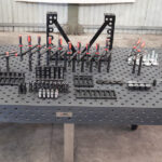 Top-down angle of a 1500x3000mm cast iron welding table showing fixtures.