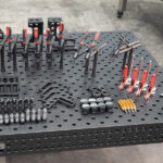 Top-down perspective of a 1500x3000mm industrial welding table showing fixtures and clamping tools.