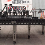 Front-on view of the 1500x3000mm nitrided steel table featuring stainless steel adjustable legs and professional workholding.