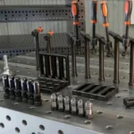 Close-up of a Tenaxis Raw Cast Iron table showcasing screw clamps, locating squares and pins.