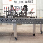 Front view of a 1500x3000mm nitrided cast iron welding table with a full professional fixture kit.