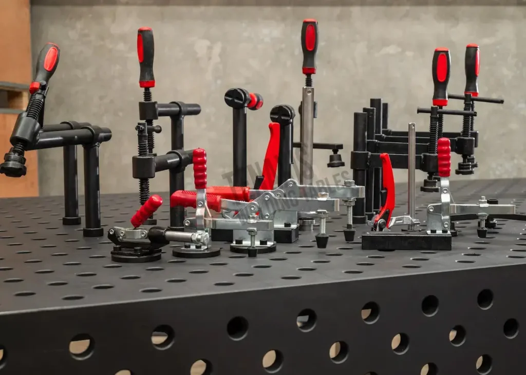 Professional modular welding fixture kit featuring heavy-duty swing clamps, horizontal clamps, and precision workholding tools on a nitrided steel welding table.
