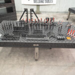 Front view of a 1500x3000mm nitrided steel welding table with a complete fixture kit