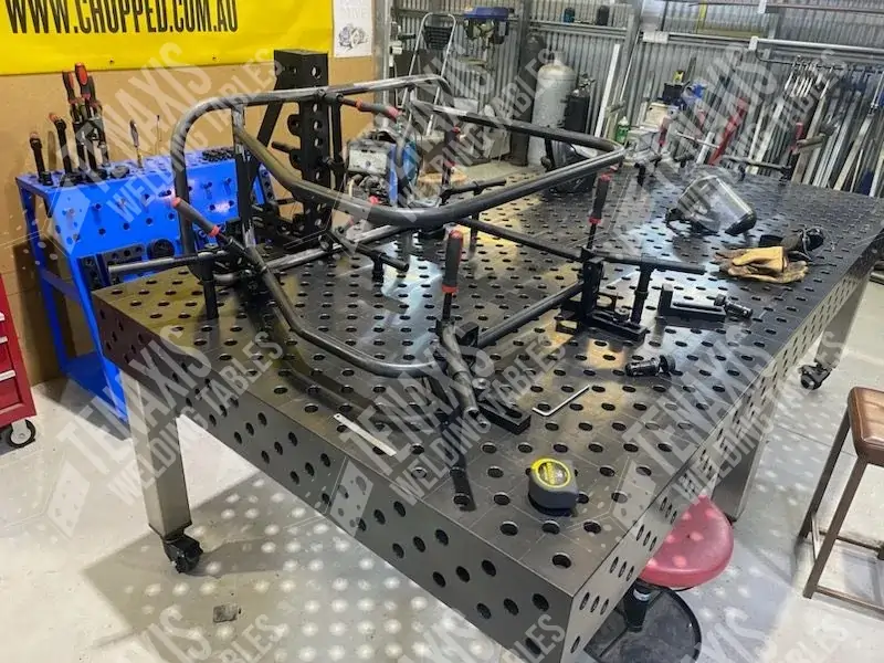 Complex tubular frame assembly for a vehicle chassis fixtured on a modular 3D welding table