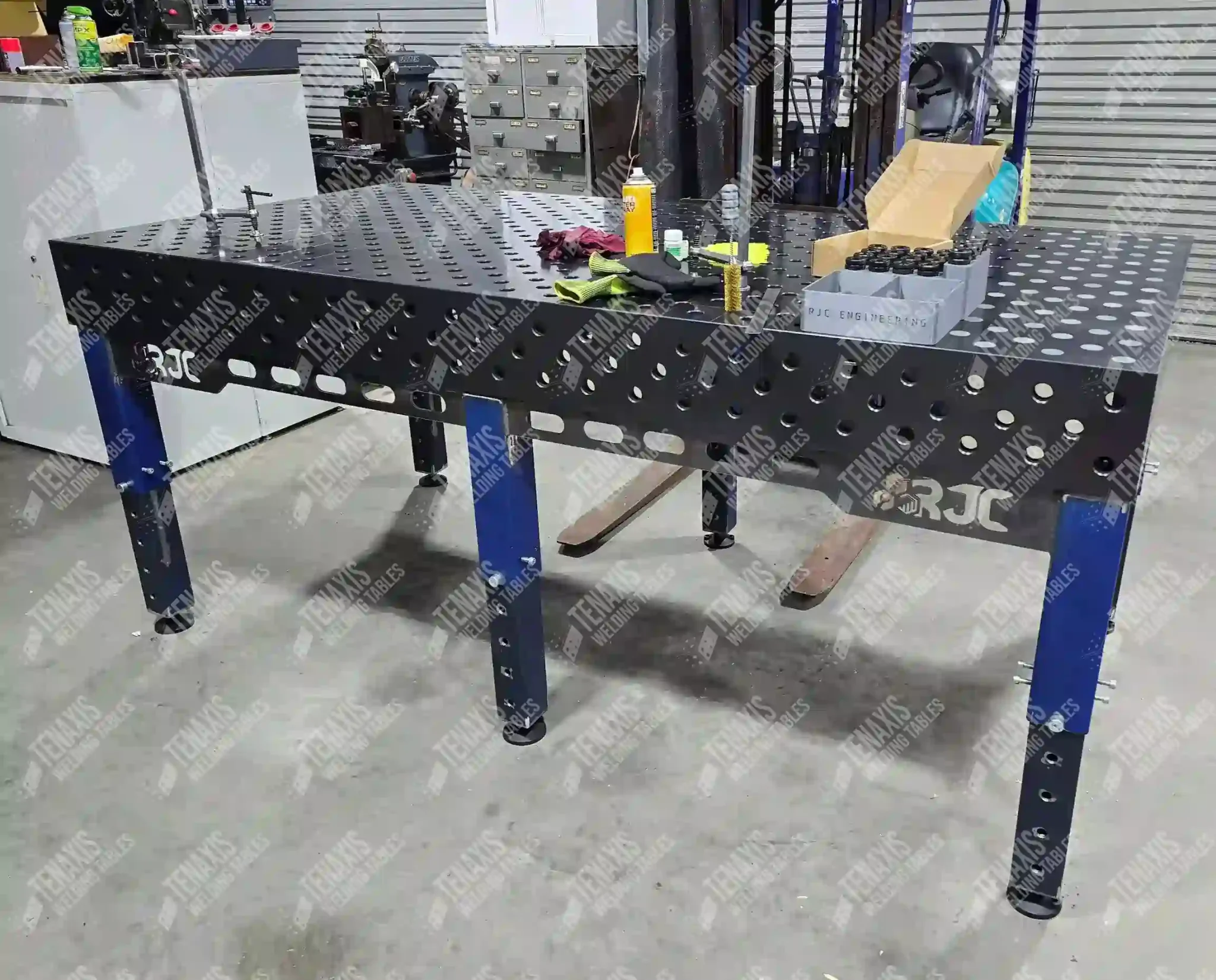 Nitrided Cast Iron Tenaxis modular welding fixture table in the middle of a fabrication shop